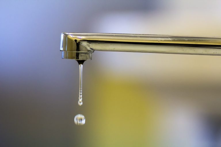 Water dripping from a chrome tap showing a leaking faucet -Leak Detection Como