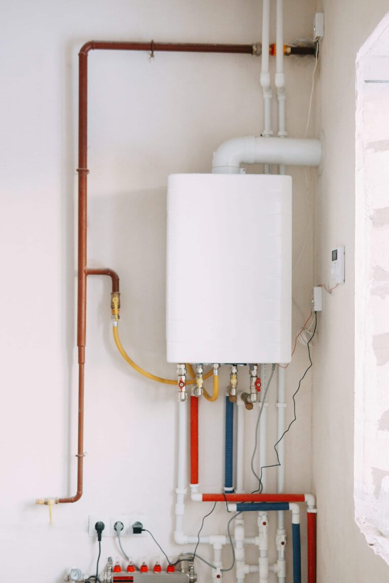 Gas boiler installation with colored pipes and valves on the wall.-Gas Appliance Installation Floreat