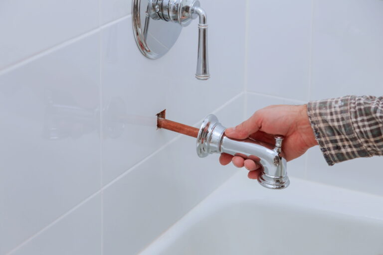 Plumber installing bathtub faucet with exposed pipe-Burst pipe repair Beldon