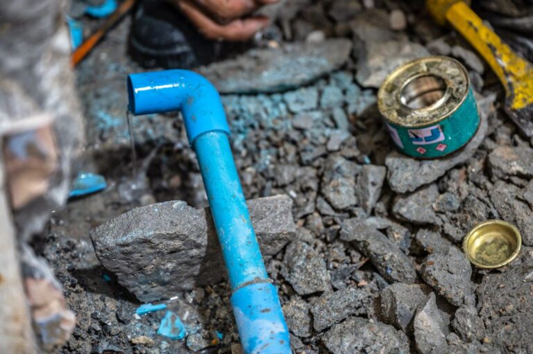 Plumber repairing a leaking pipe